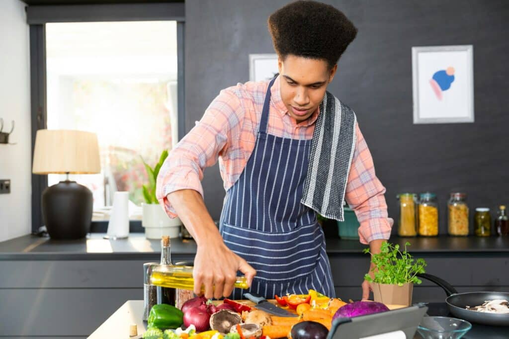 homme legumes avec de l huile dans la cuisine